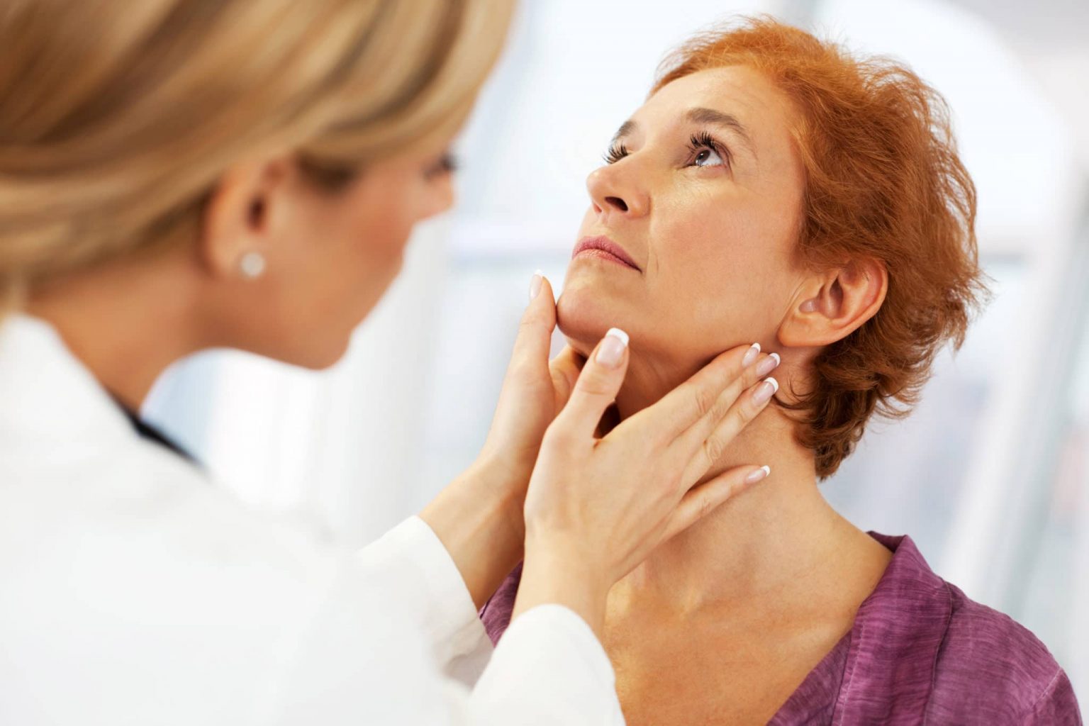 tonsillitis-symptoms Otolaryngologist feeling a patient's neck checking for tonsillitis.
