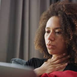 Woman with a sore throat resting at home.