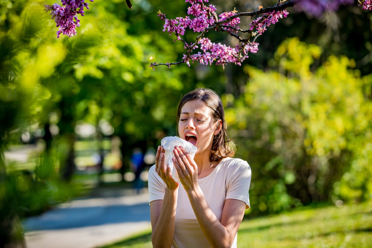 Woman sneezes from allergies