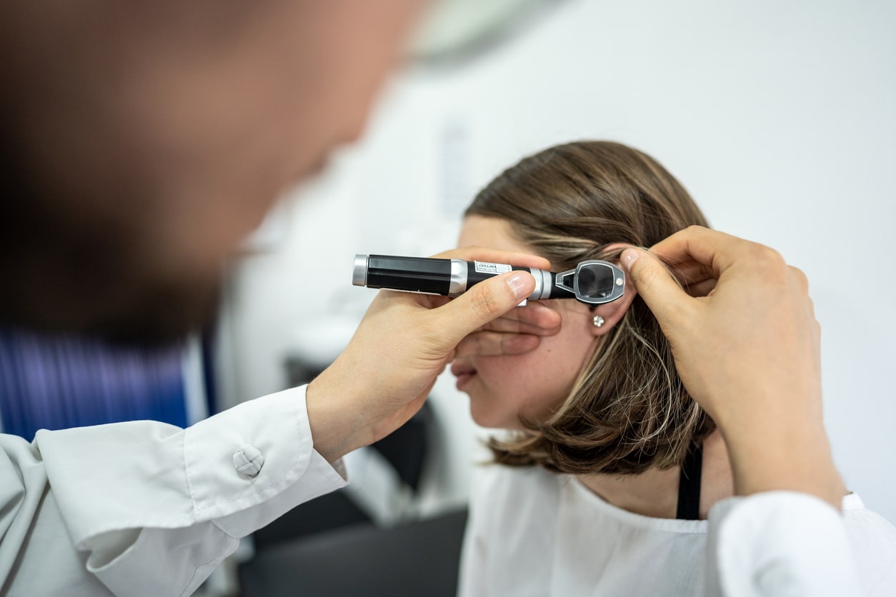 ENT specialist looking inside a patient's ear.