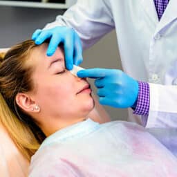 ENT specialist realigning a patient's nose