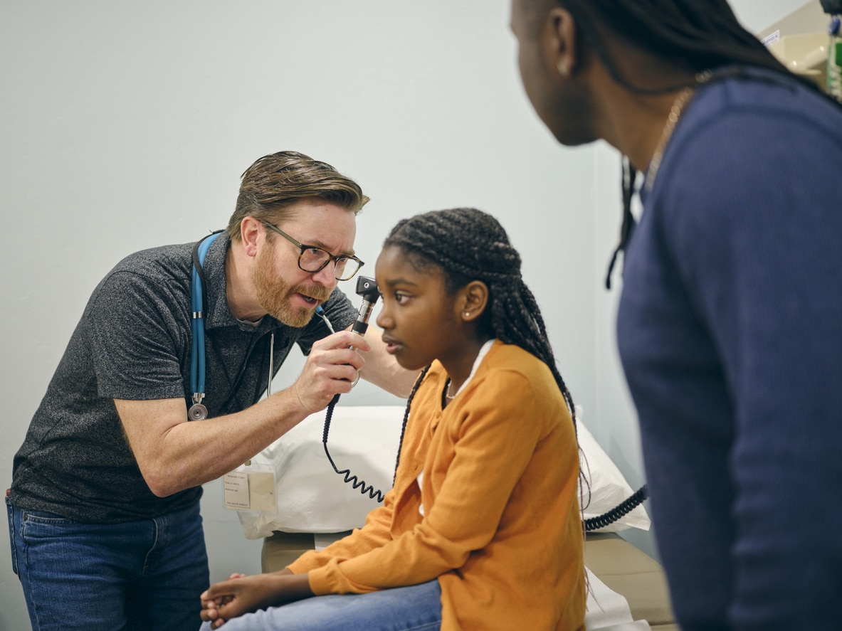 ENT examining a young girl's ear.