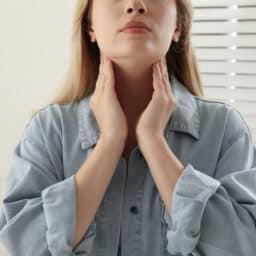 Woman feeling her neck