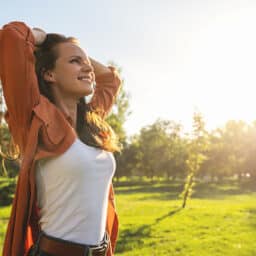 Woman takes a deep breath on a beautiful summer day.
