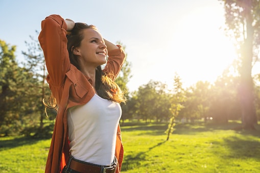 Woman takes a deep breath on a beautiful summer day.