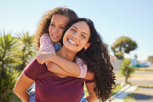 Happy mother and daughter hugging on a beautiful day.